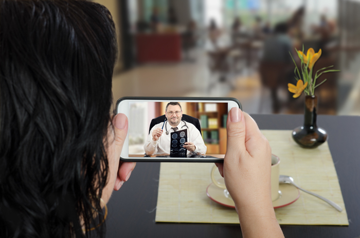 Woman has a telehealth therapy session via her mobile phone