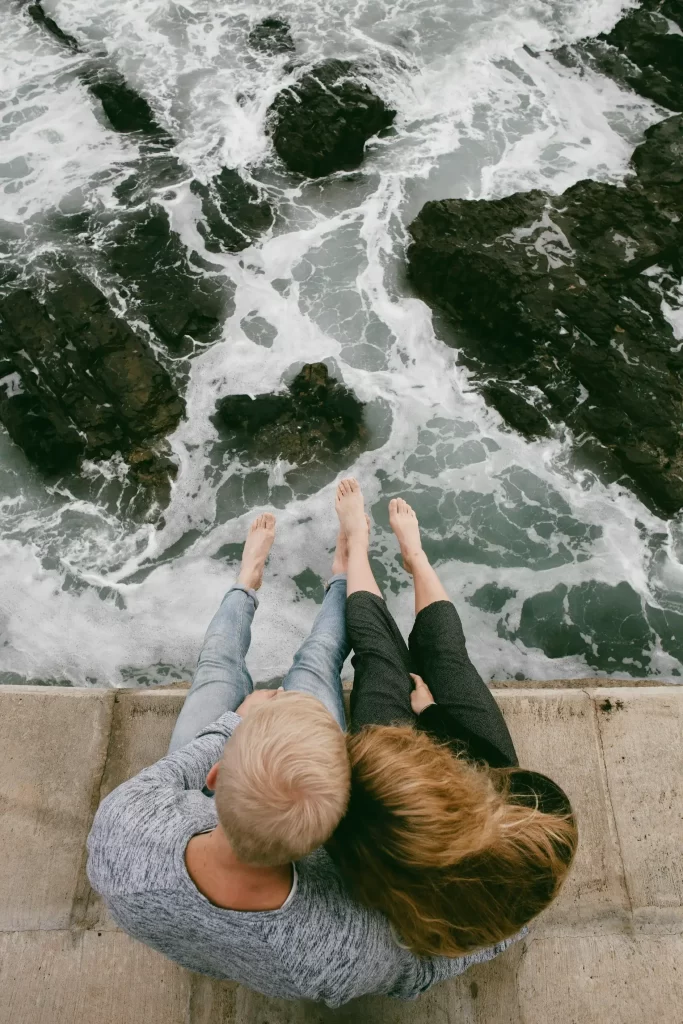 couple sitting near the ocean in warm clothing, talking about desire descrepancy in their relationships